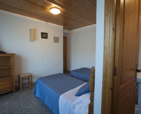 Habitació amb llits individuals, bany i televisió
